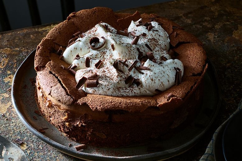 Chocolate cake with cream on top and chocolate shavings.